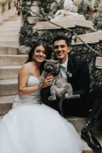 married couple posing with grey cat